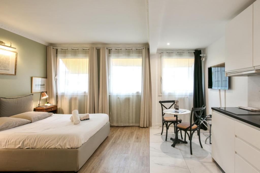 a bedroom with a bed and a table and a kitchen at Charming studio near Tour Eiffel Invalides Beaugrenelle in Paris