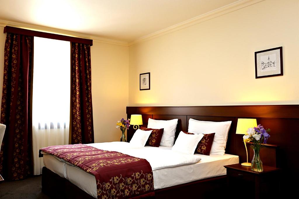 een hotelkamer met een bed en een raam bij Oroszlános Borhotel in Tállya