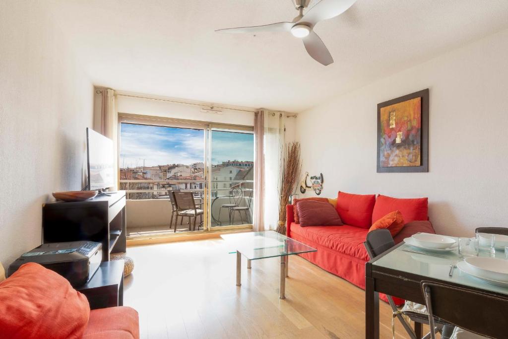 ein Wohnzimmer mit einem roten Sofa und einem Glastisch in der Unterkunft Quartier Vauban 2 bedroom apartment in Antibes