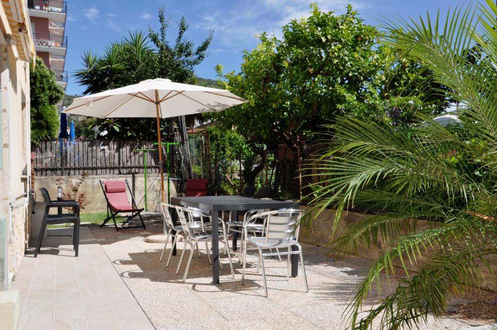 a table and chairs with an umbrella on a patio at Via Battisti 231 1 in Pietra Ligure