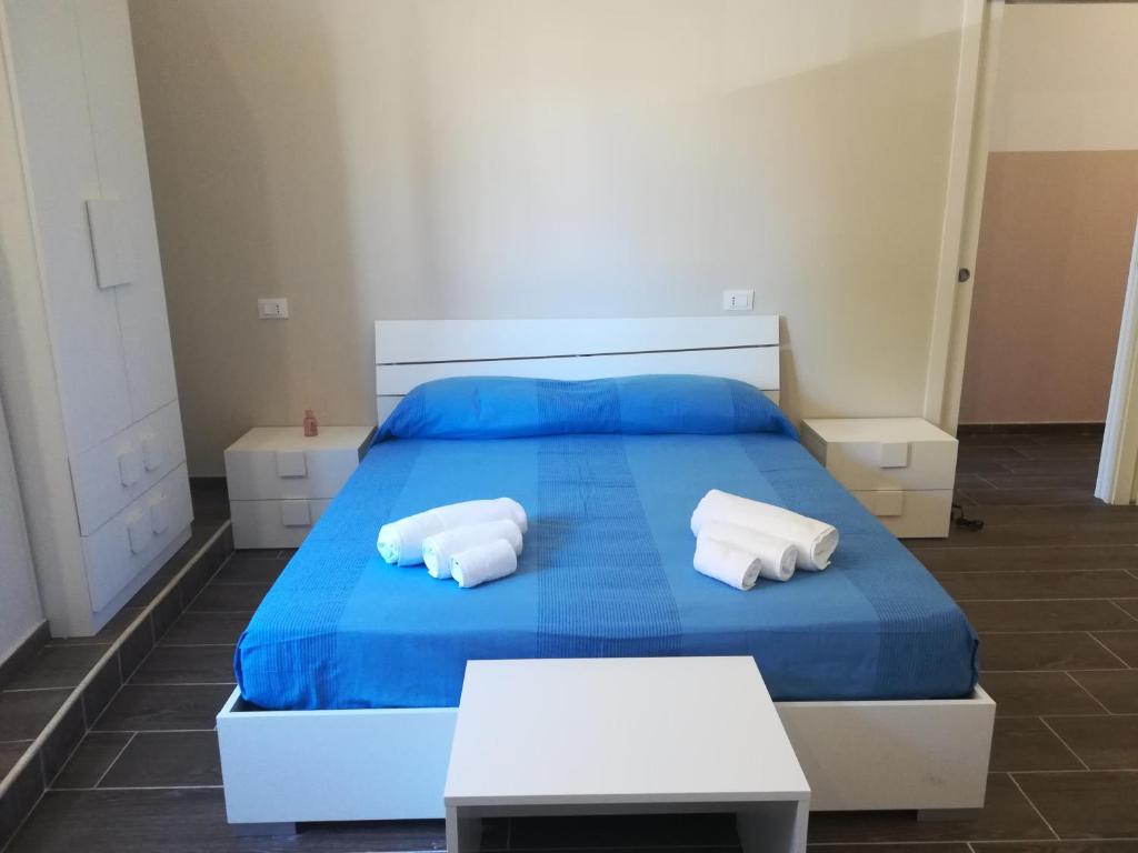 ein Schlafzimmer mit einem blauen Bett mit zwei weißen Kissen in der Unterkunft Scilla Upper Town in Scilla