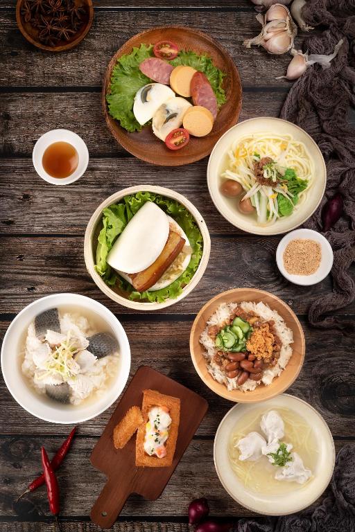 a group of plates of food on a wooden table at Taipung Suites in Anping