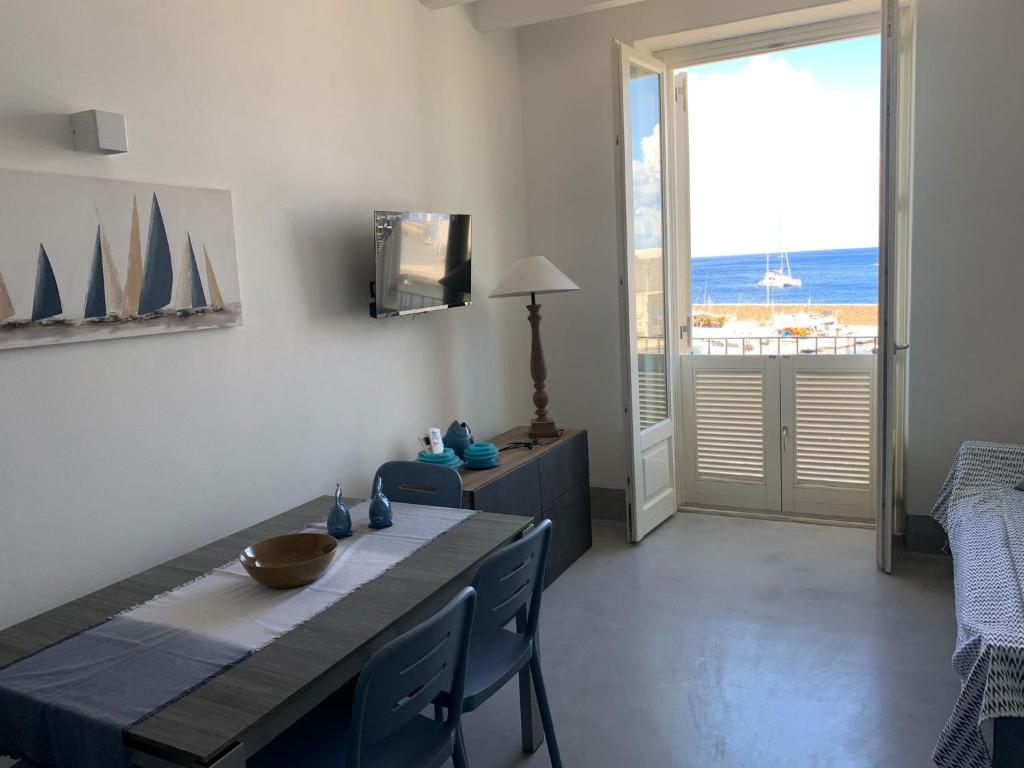 a dining room with a table and a view of the ocean at Appartamenti Marina Corta in Lipari