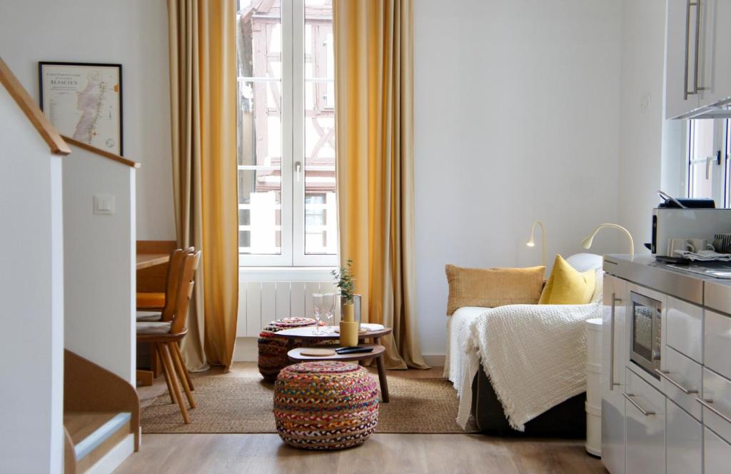una camera con letto, tavolo e finestra di La Cour du Vignoble a Kaysersberg