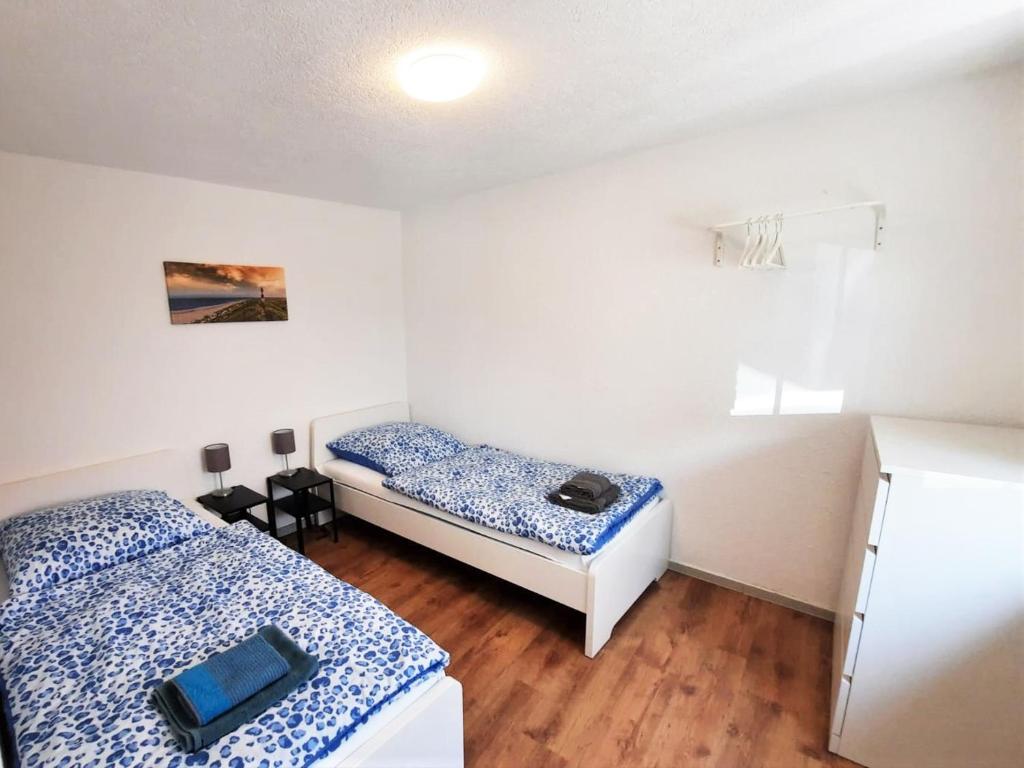 ロイトリンゲンにあるWork& Stay Apartment mit 2 Schlafzimmernのベッド2台とテーブルが備わる小さな客室です。