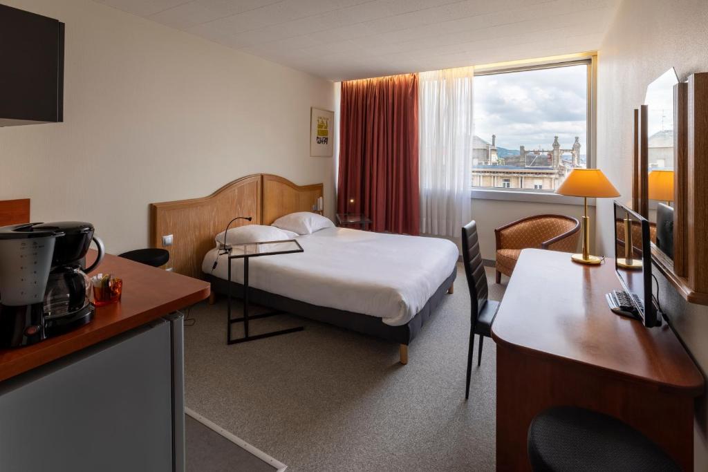 ein Hotelzimmer mit einem Bett, einem Schreibtisch und einem Fenster in der Unterkunft The Originals Residence, Kosy Nancy Coeur de Ville in Nancy
