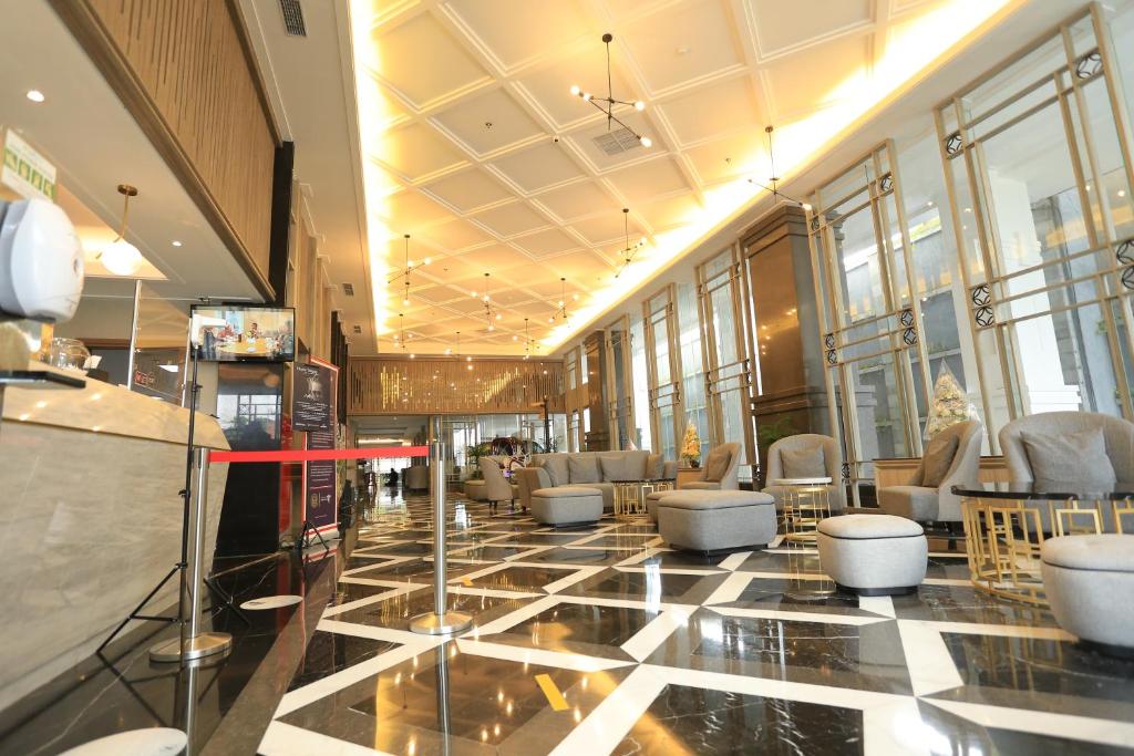 a lobby with chairs and tables in a building at Solia Zigna Kampung Batik Laweyan in Solo