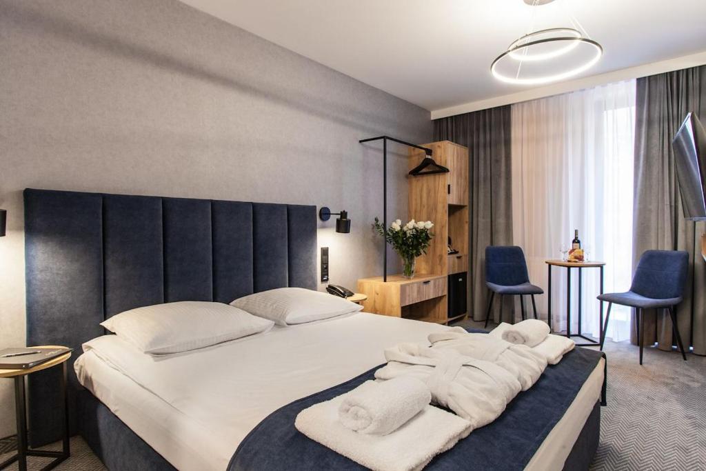 فندق ألكسندر في كراكوف: غرفة نوم بسرير كبير عليها مناشف