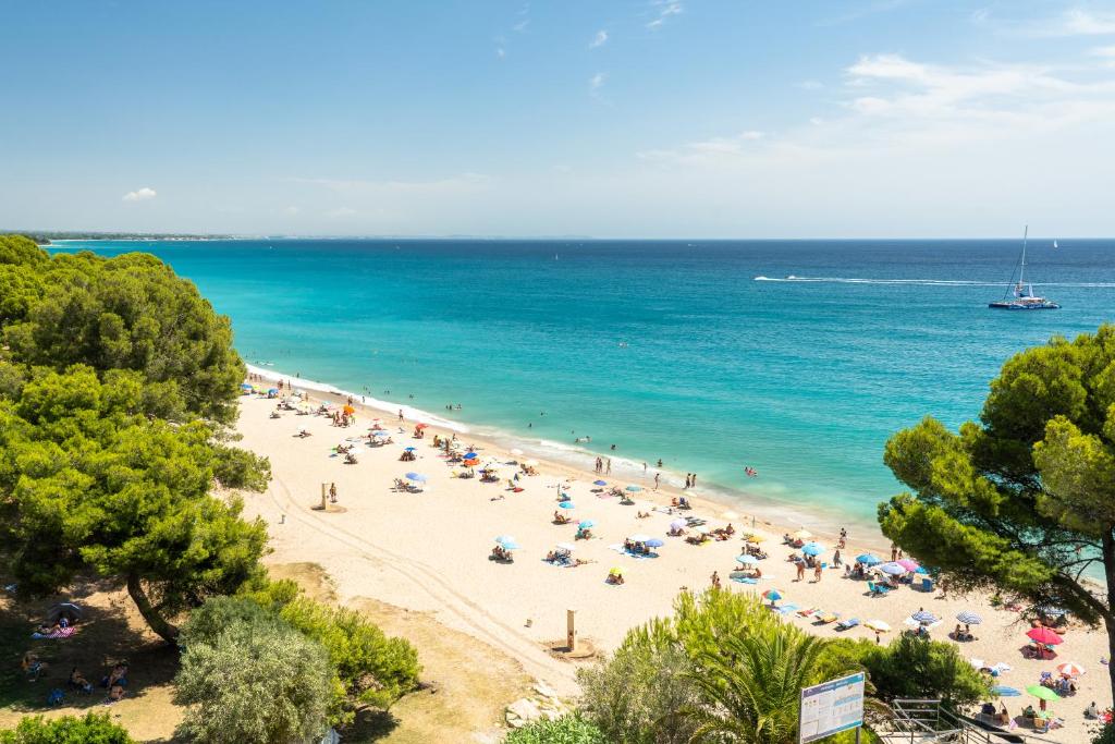 a group of people on a beach with the ocean at Hauzify I Apartaments Panoramic in Miami Platja