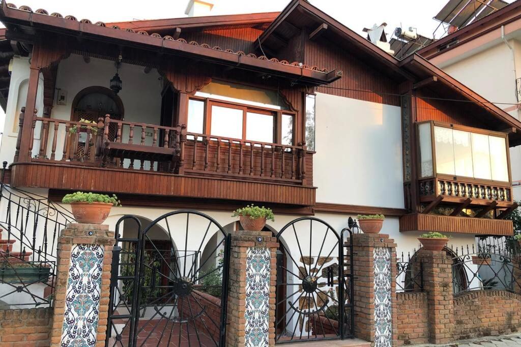 a house with a balcony and a fence at A summer house is close to the sea with a garden in Fethiye