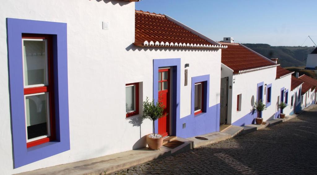 a row of houses with red and blue doors at Casas Do Moinho - Turismo De Aldeia in Odeceixe