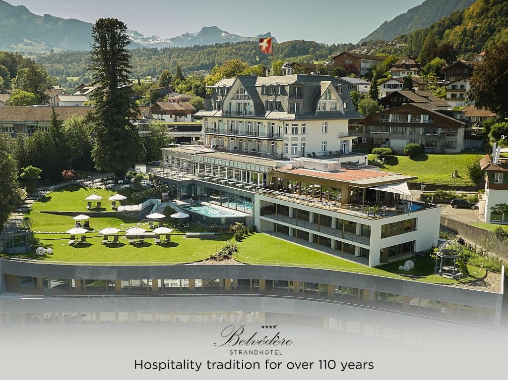 a large building with a lawn in front of it at Belvédère Strandhotel in Spiez
