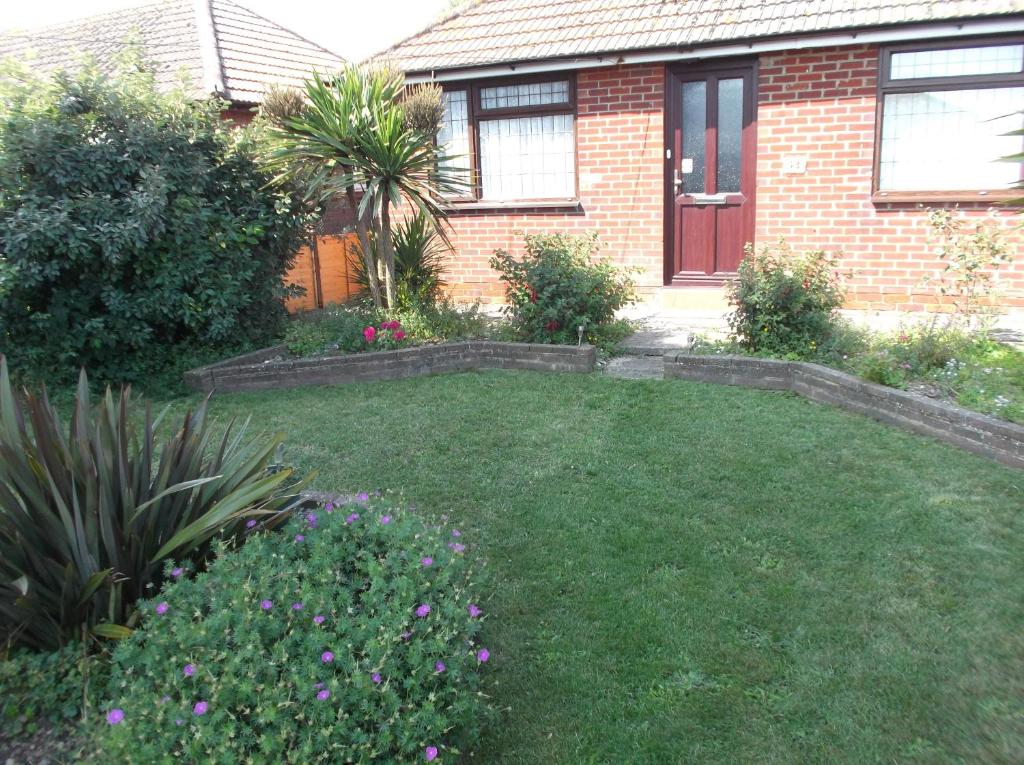 a yard in front of a brick house at Sea Shells in Greatstone