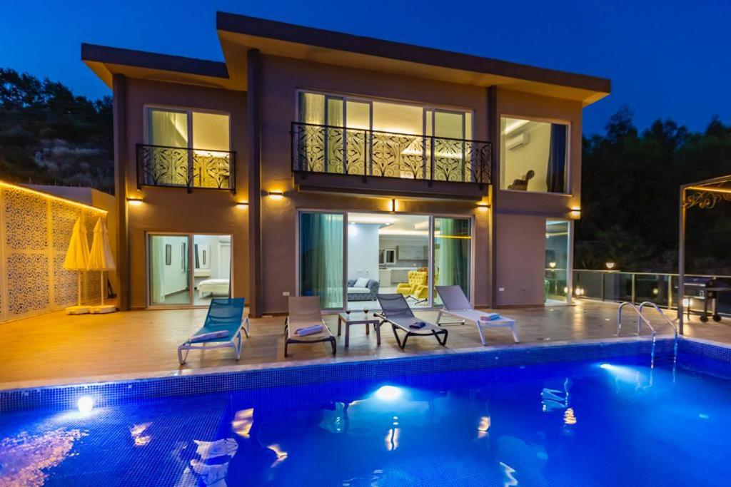 a house with a swimming pool in front of a house at LA VILLA CELINE- XLarge villa complete privacy in nature, pool with wondeful view in Kalkan