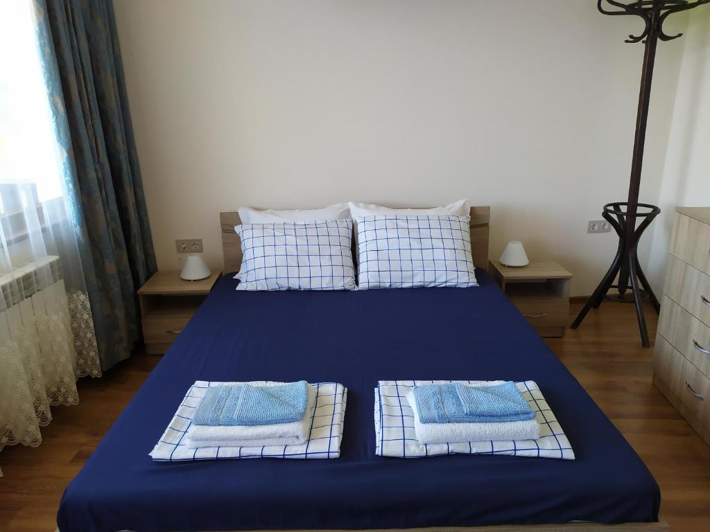 a bed with blue sheets and pillows in a room at Stefi house in Veliko Tŭrnovo