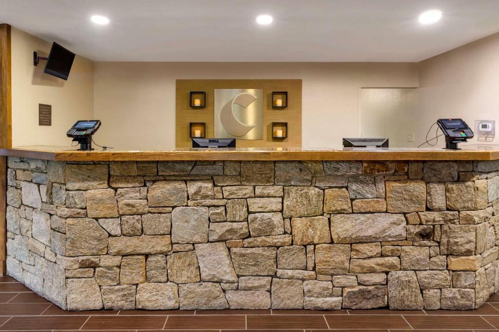 a stone bar in a hotel lobby with a stone wall at Comfort Suites Boone - University Area in Boone