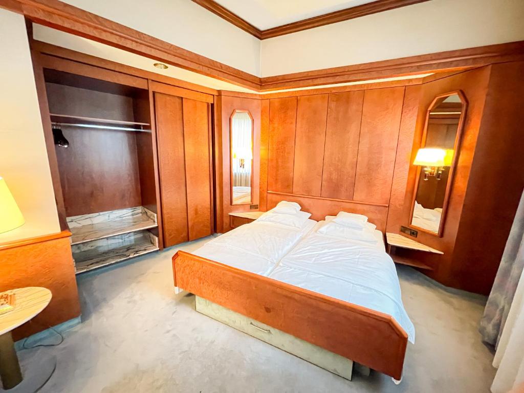 1 dormitorio con 1 cama grande y paredes de madera en Gästehaus Sophienstraße, en Stuttgart