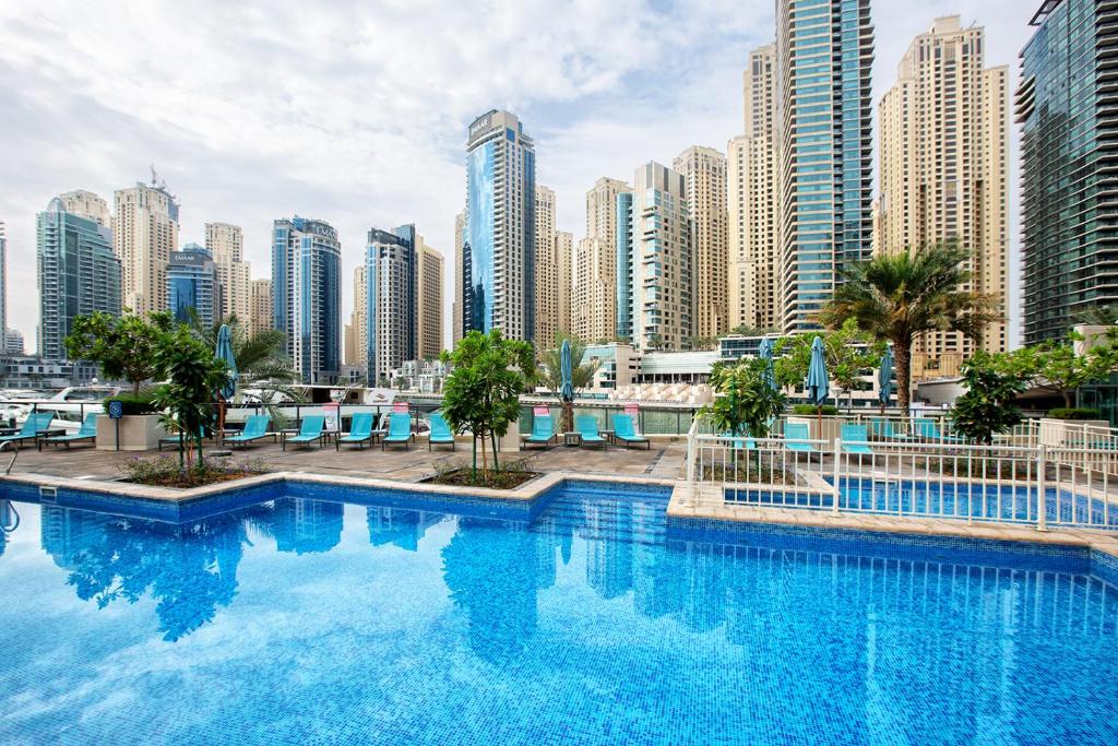 杜拜的住宿－Al Majara by EMAAR, Dubai Marina，一座位于城市的游泳池,有高大的建筑