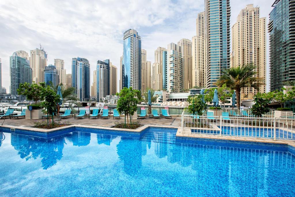 a large swimming pool in a city with tall buildings at Al Majara by EMAAR, Dubai Marina in Dubai