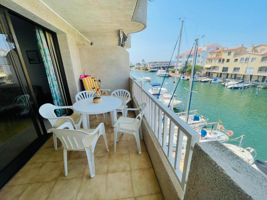 a balcony with a table and chairs and a view of the water at PORT ROYAL B1 2-2 - Apartamento con vistas al canal - cerca playa in Empuriabrava
