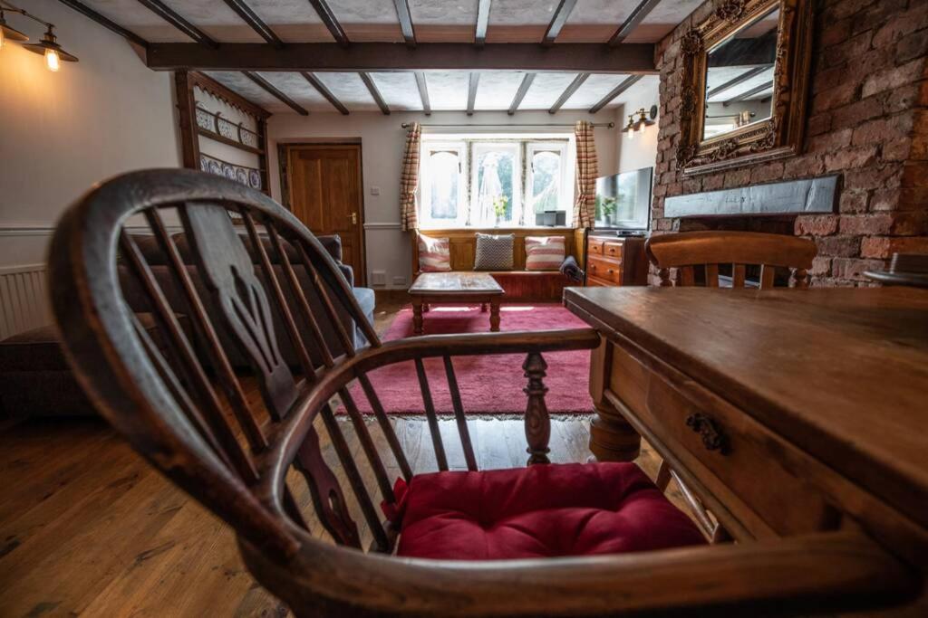 uma sala de estar com uma mesa de madeira e uma cadeira em Clay Well Cottage em Huddersfield