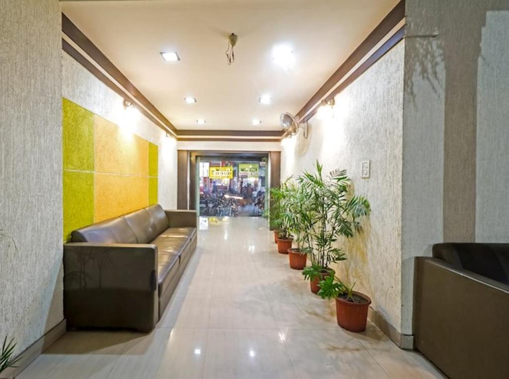 a lobby with a couch and potted plants at Hotel Palace in Amritsar