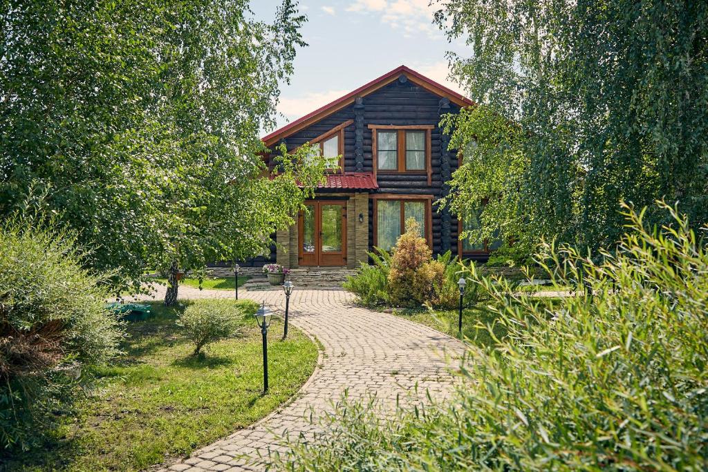 a wooden house with a stone path leading to it at Lovchiy Plus in Tolyatti