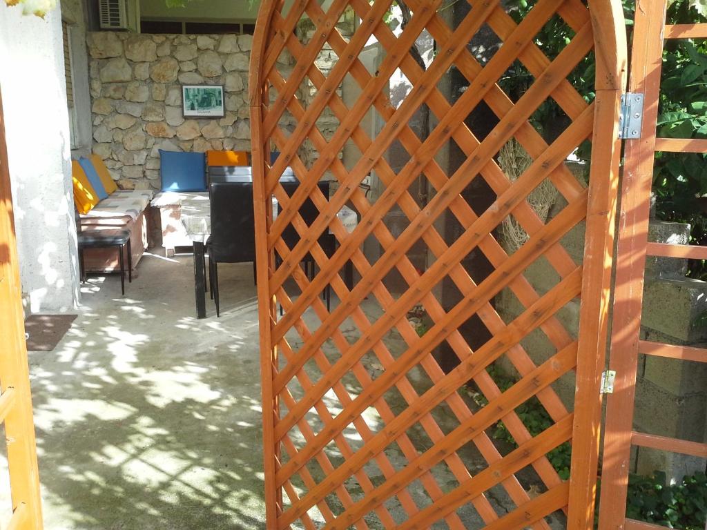 ein Holztor zu einem Wohnzimmer mit einem Tisch in der Unterkunft Isabele in Brodarica