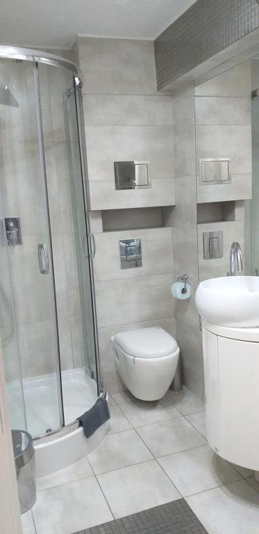 a bathroom with a shower and a toilet and a sink at Apartamenty Centrum Rynek Mała Dwójka in Kielce