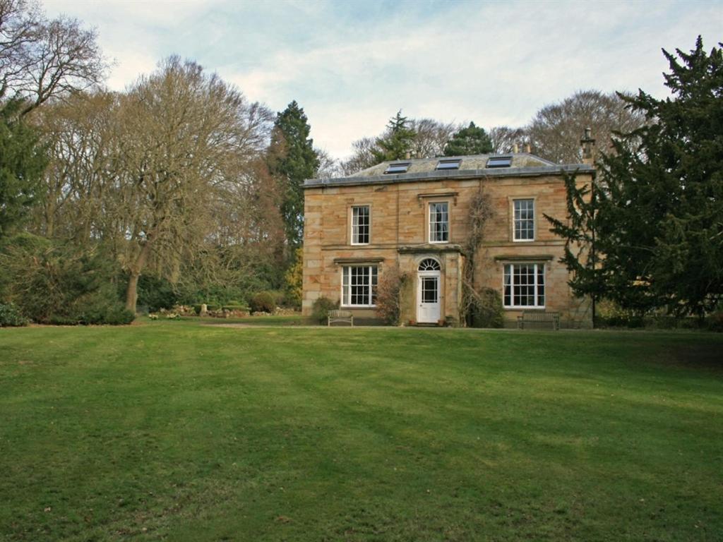 a large brick house with a large grass yard at Burnhopeside Hall in Lanchester