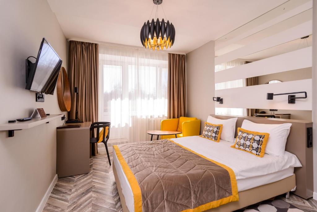 Habitación de hotel con cama y escritorio en Ugor Hotel, en Syktyvkar