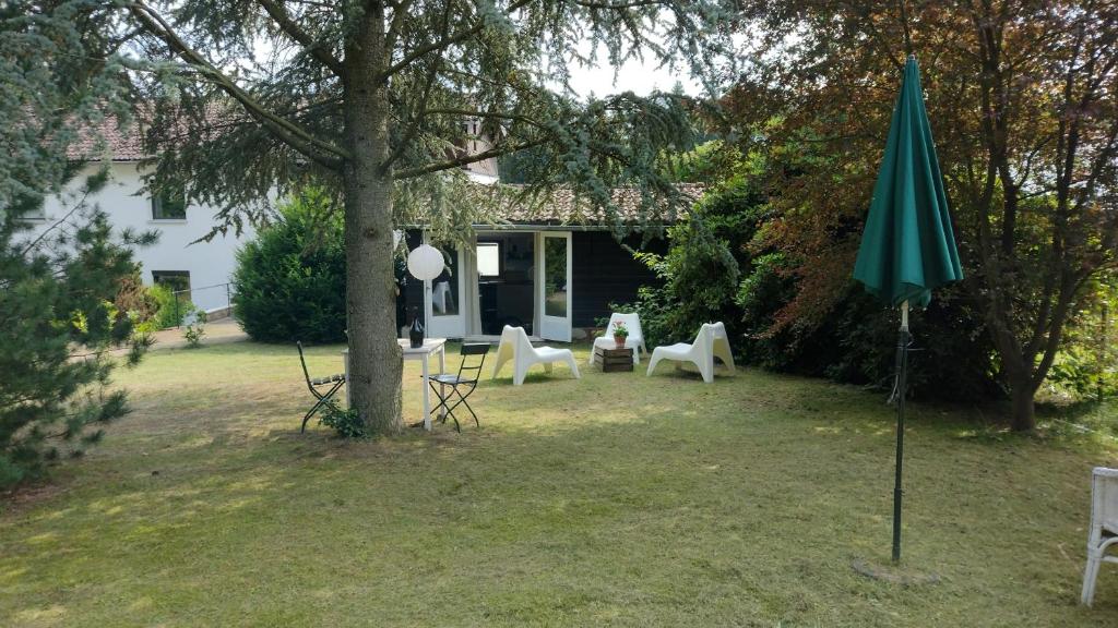 einen Garten mit Stühlen und einem Regenschirm vor einem Haus in der Unterkunft Chalet in Bad Sachsa