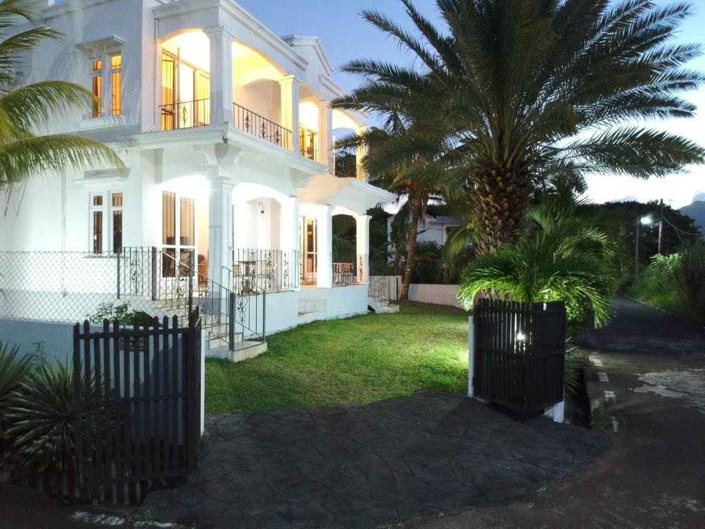 una casa blanca con dos palmeras en el patio en Tam Studio, en La Gaulette