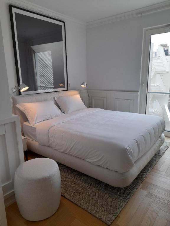 ein Schlafzimmer mit einem großen weißen Bett und einem Stuhl in der Unterkunft Lisbon, Wifi, AC in Lissabon
