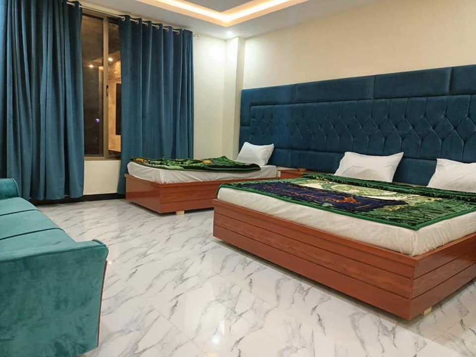 a bedroom with two beds and a blue headboard at Hotel Mi-Amore in Naran