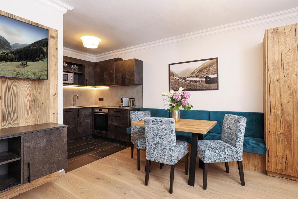 a kitchen with a wooden table and chairs at Living Central in Grossarl