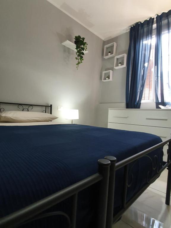 una camera da letto con un letto con lenzuola blu e una finestra di LA MAISON DELUXE LODI a Lodi