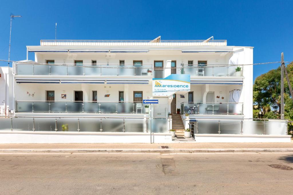 a white building on the side of a street at Maresidence - il Residence sul mare a Torre Pali in Torre Pali