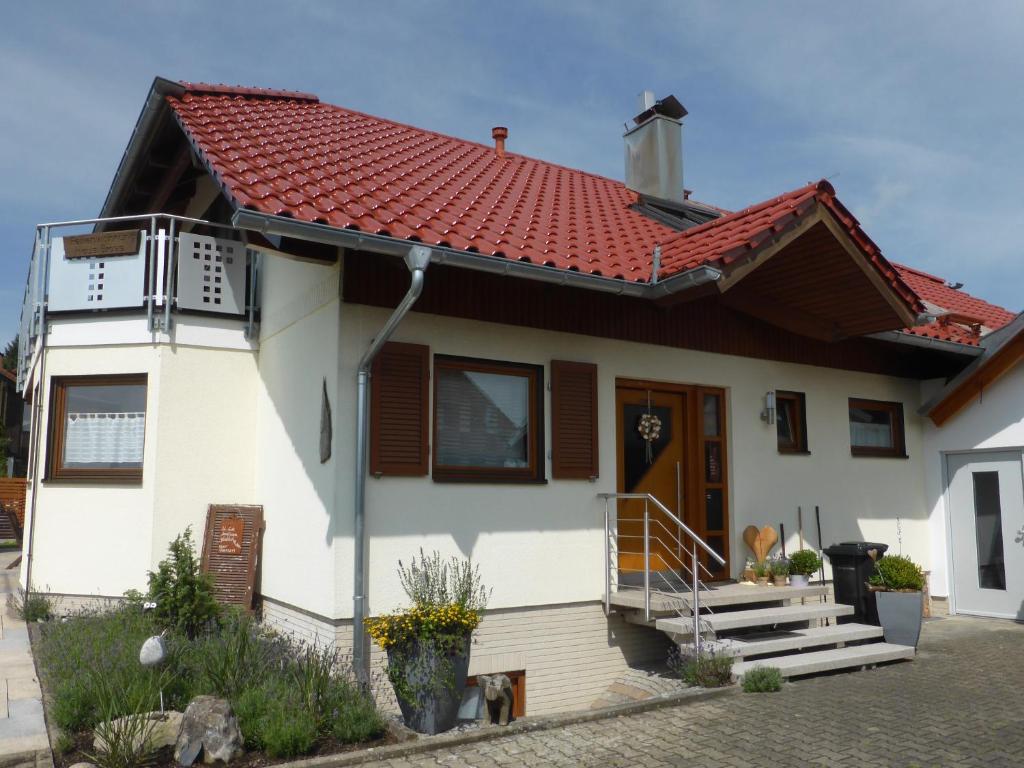 a white house with a red roof at Haus Bross in Hayingen