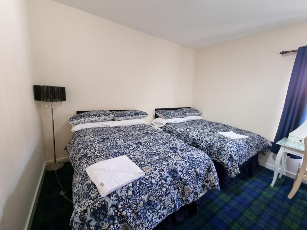 2 Betten nebeneinander in einem Zimmer in der Unterkunft Carnarvon Street City Centre Apartment in Glasgow