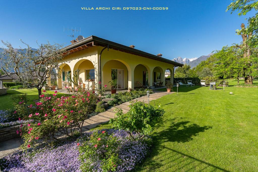 una casa con un jardín con flores en el patio en Villa Archi en Colico