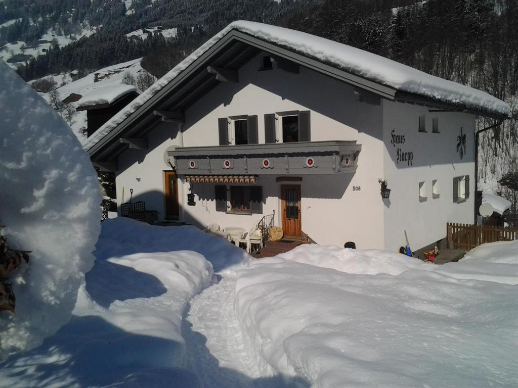 a house covered in snow with a pile of snow at Haus Ruepp in Silbertal