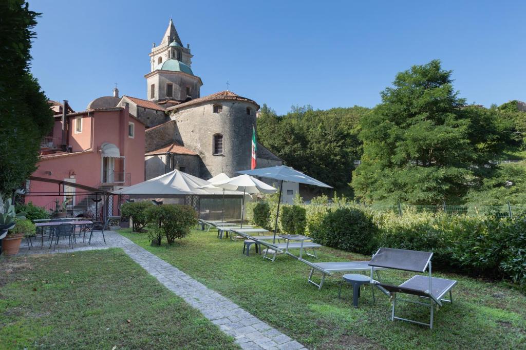 un grupo de mesas y sillas frente a un edificio en Hotel Al Convento, en Vezzano Ligure