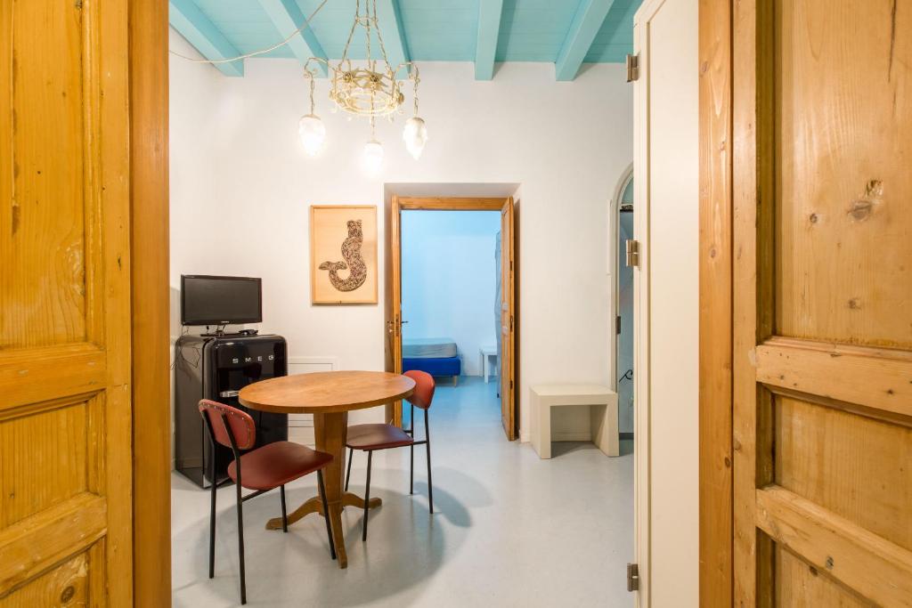 una sala da pranzo con tavolo e sedie di Nuvole Residenza by Wonderful Italy a Palermo