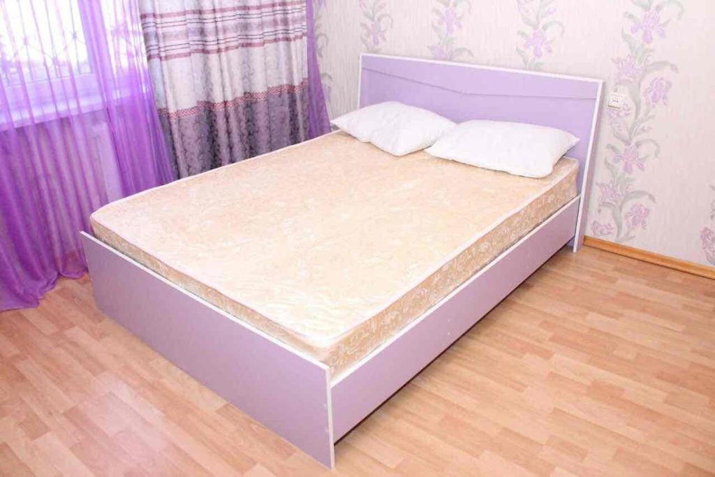 łóżko z dwoma poduszkami w sypialni w obiekcie Зеленая лощина w mieście Ałma-Ata
