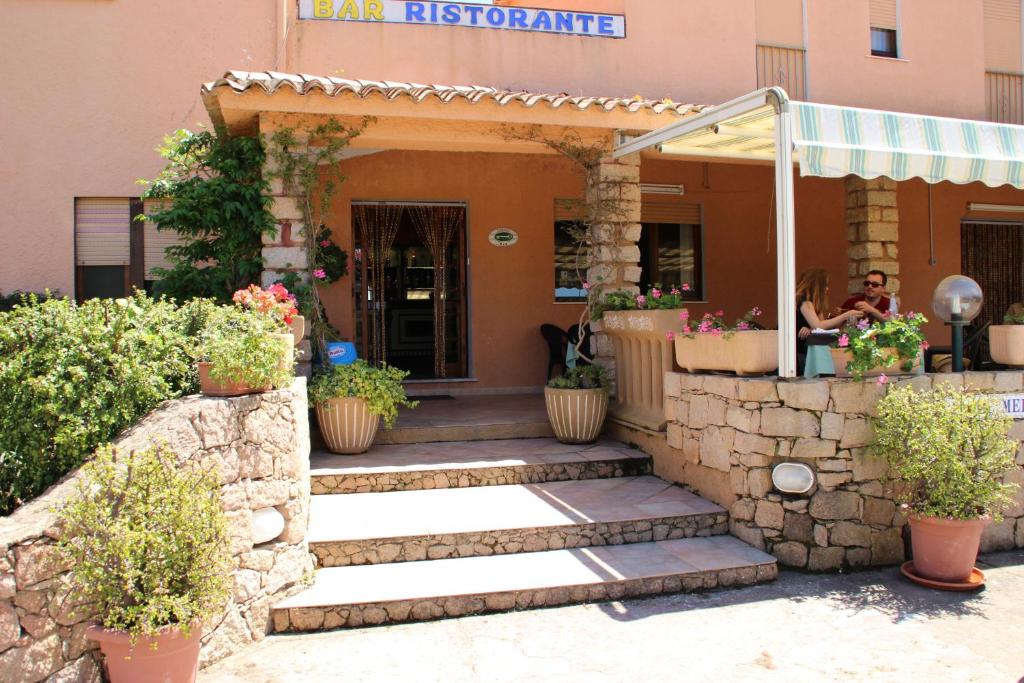 Zugang zu einem Gebäude mit Topfpflanzen in der Unterkunft Hotel Mediterraneo in Costa Paradiso