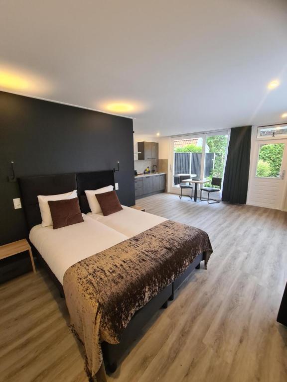 um quarto com uma cama grande e uma parede preta em Tip Top Studio Vlissingen em Vlissingen