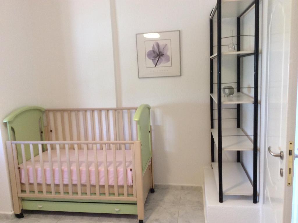 a room with a crib and a shelf at Red House in Gerakini