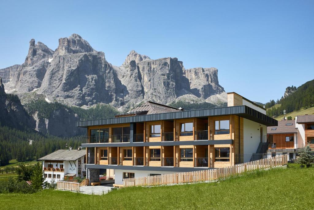 a house with a mountain in the background at Hotel Sport in Colfosco