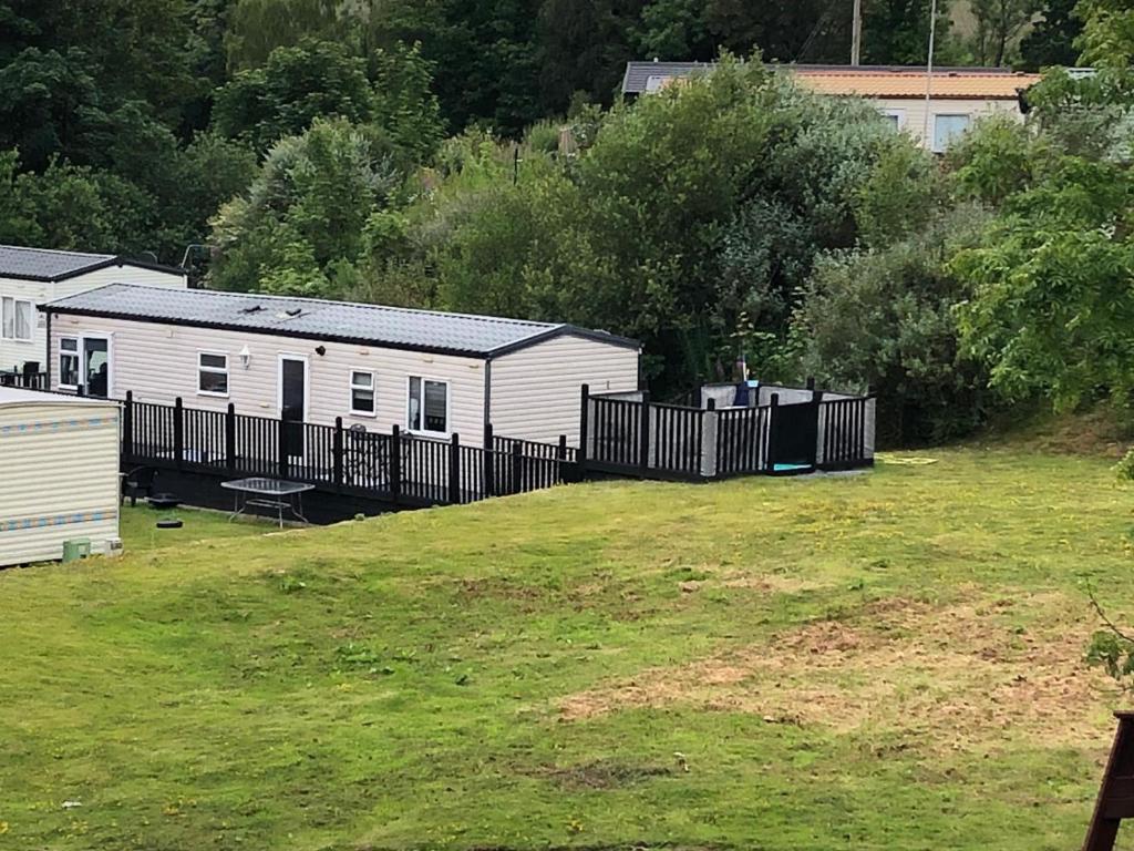 ein Hof mit einem Zaun und zwei Mobilheimen in der Unterkunft 4 Squirrel View in Stranraer
